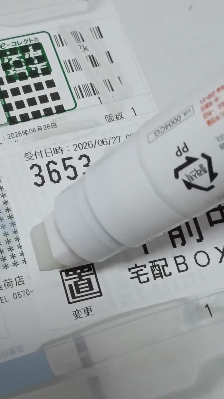 宅配伝票の上に置かれた白いペン