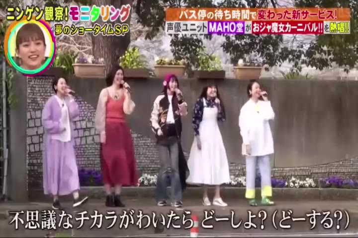 声優ユニットがバス停の前で歌い出す場面