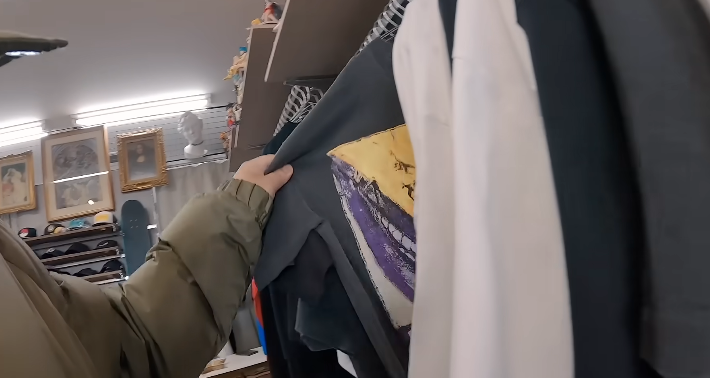 ラックにかかった服をめくっているところ