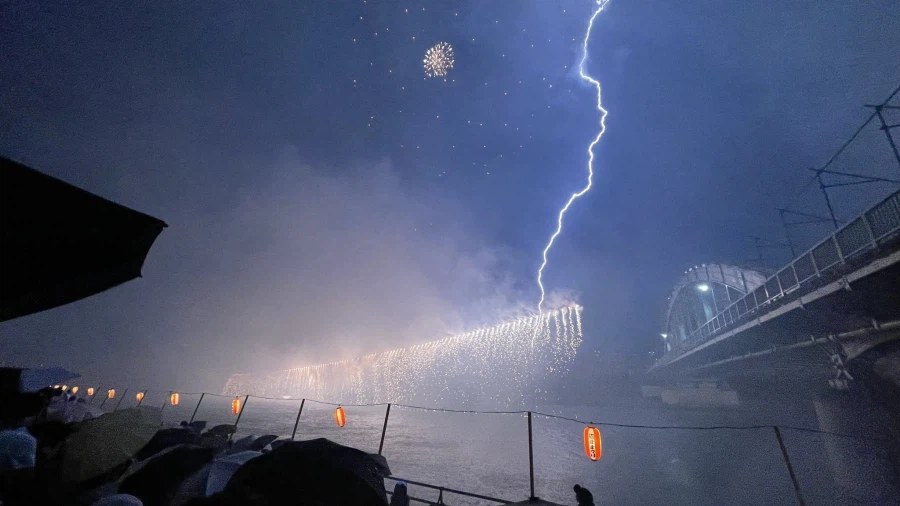 豪雨と雷の中で打ち上げられた日本の花火大会の写真