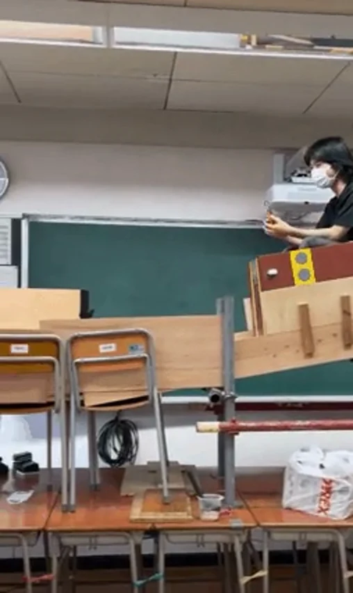 教室の机の上に組まれた木製のコースター用レール