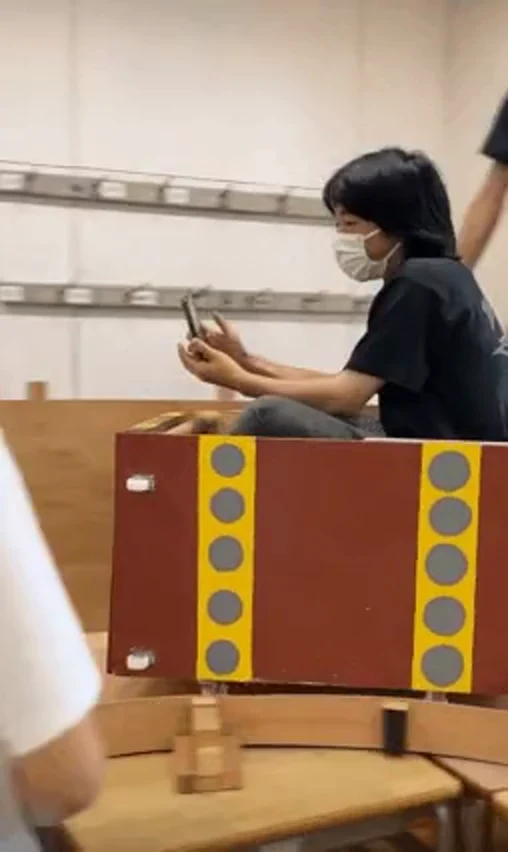 手作りのコースターの車体に乗る生徒