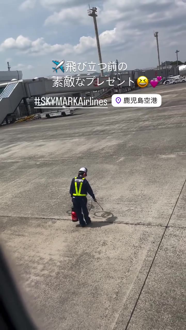 鹿児島空港の駐機場でジョウロを持って立つ地上係員