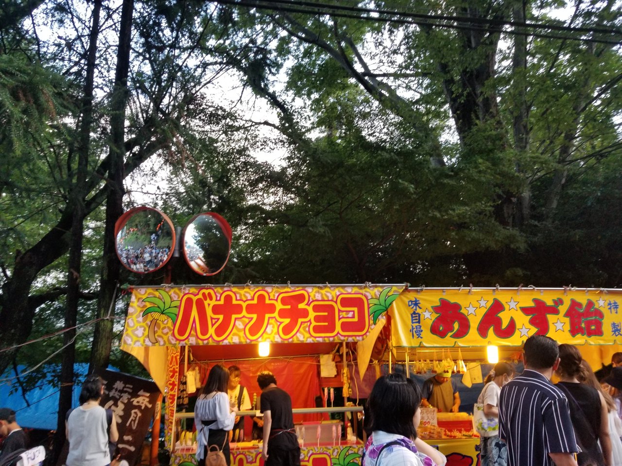 祭りの参道に並ぶバナナチョコとあんず飴の屋台