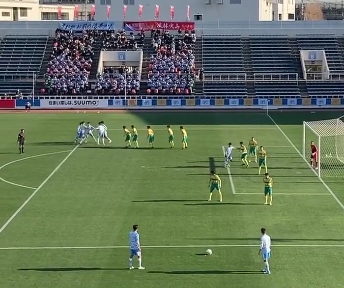 フリーキックの前に輪になって手をつなぐ高校サッカーの選手たち